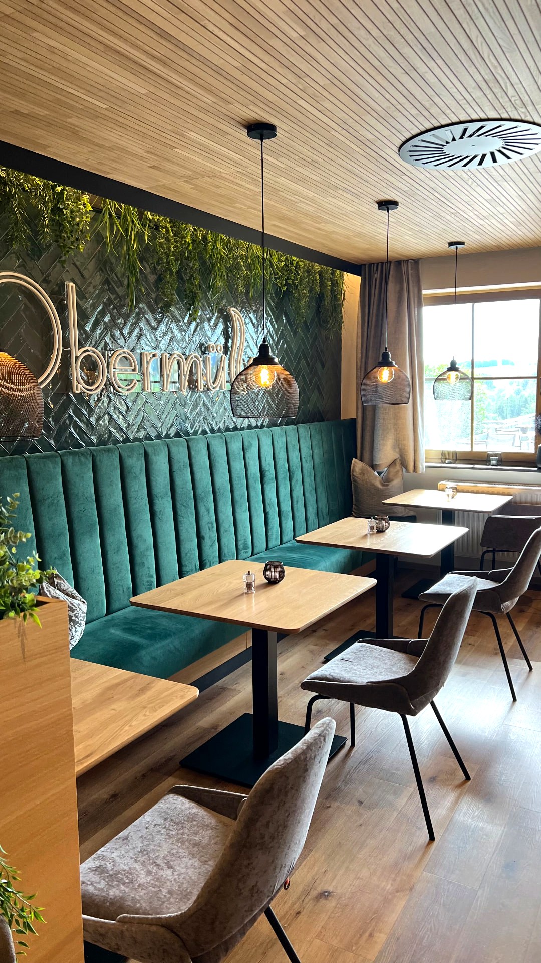Gemütliches Restaurant mit grüner Polsterbank im Landrefugium Obermüller